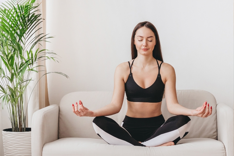 woman doing meditation on a sofa